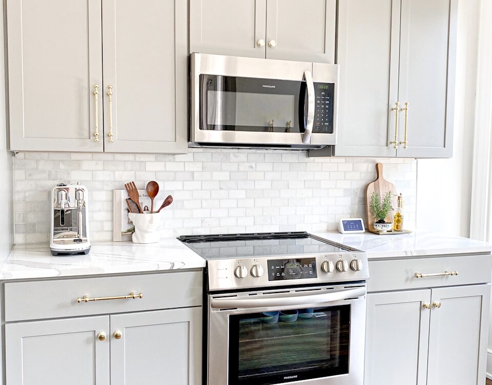white microwave oven on white wooden cabinet