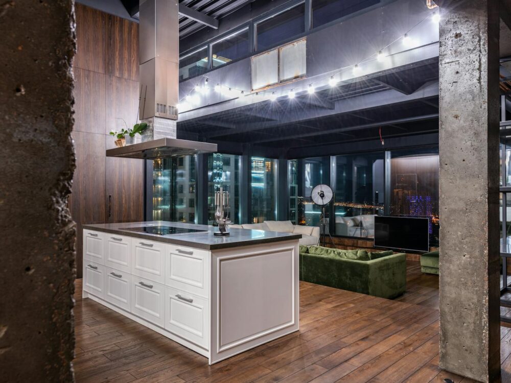 Spacious contemporary loft apartment featuring sleek kitchen and cityscape view.