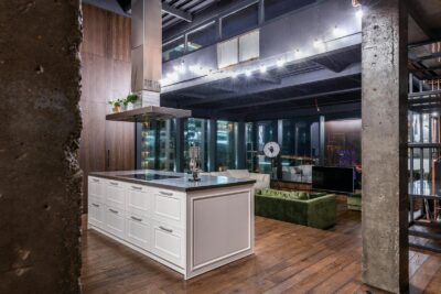 Spacious contemporary loft apartment featuring sleek kitchen and cityscape view.